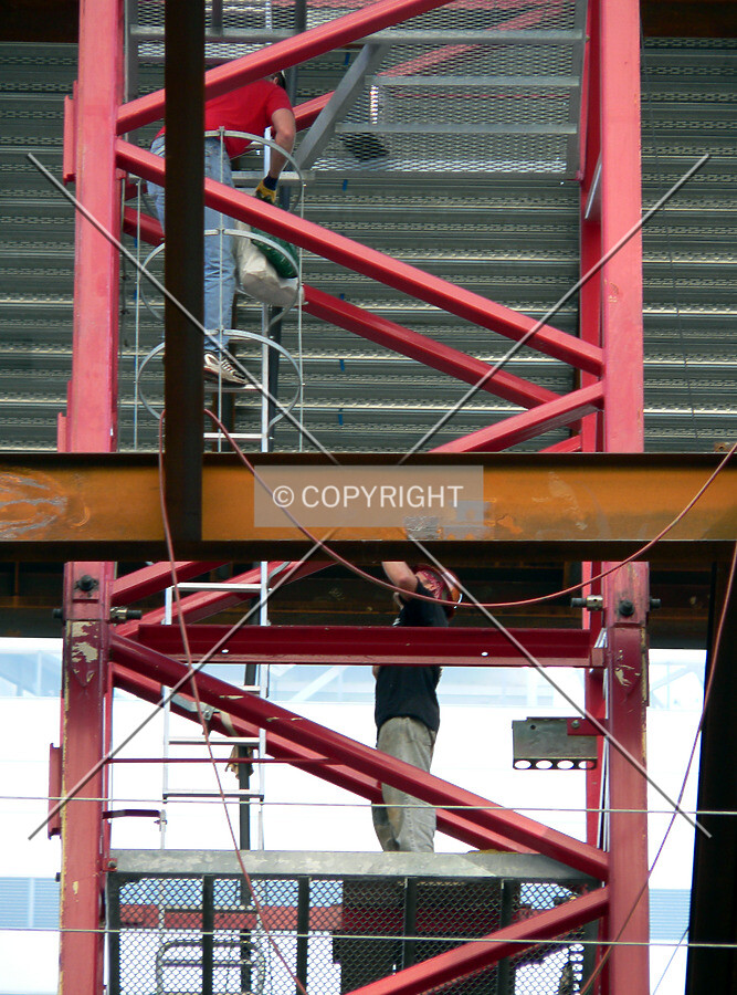 Workers ascending the tower crane