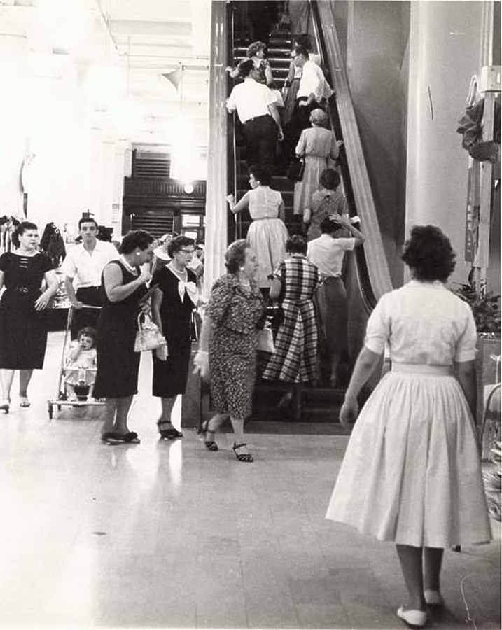 Shoppers boarding an escalator; July 25, 1959