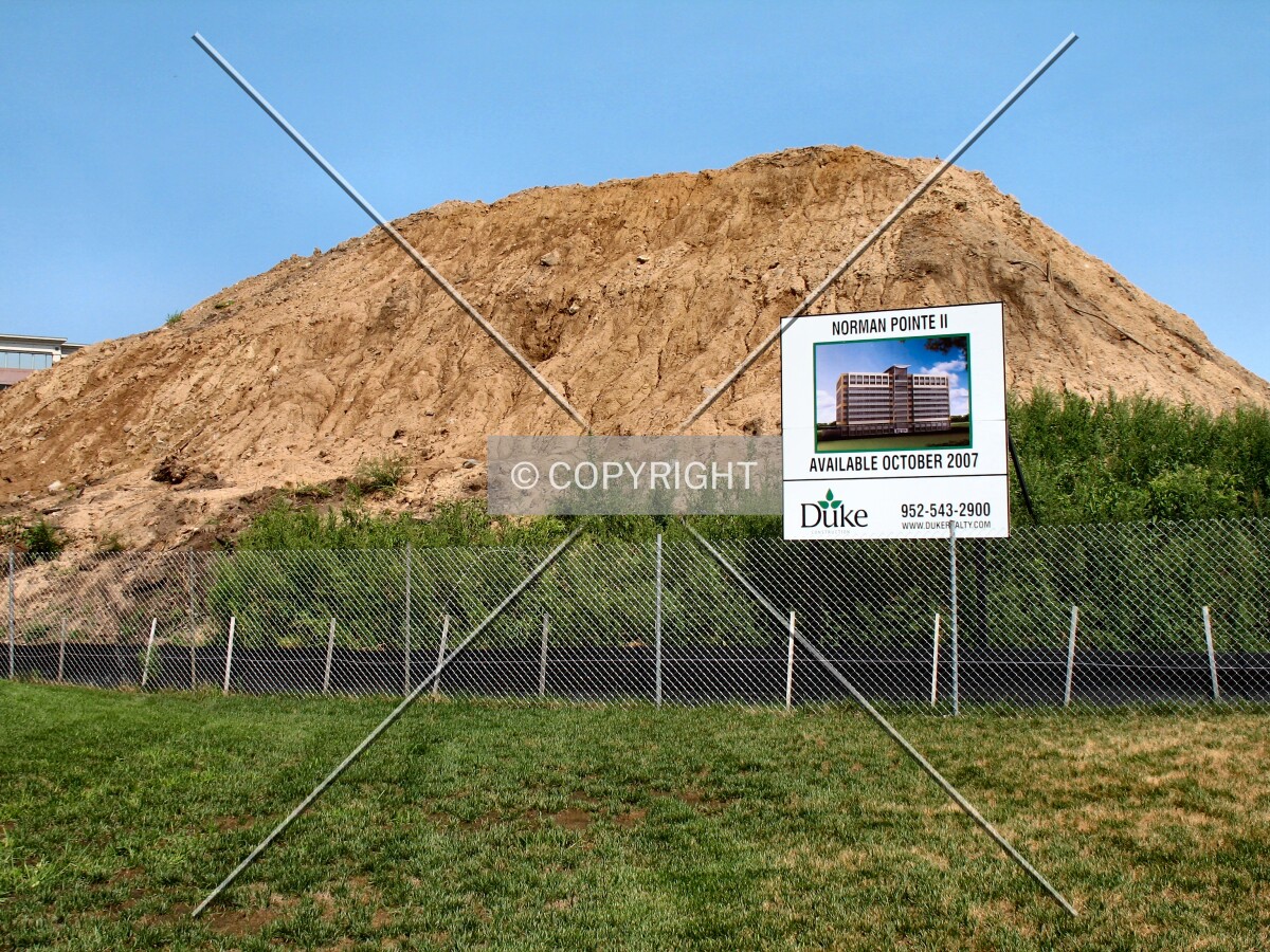 Excavated earth and project board from American Boulevard