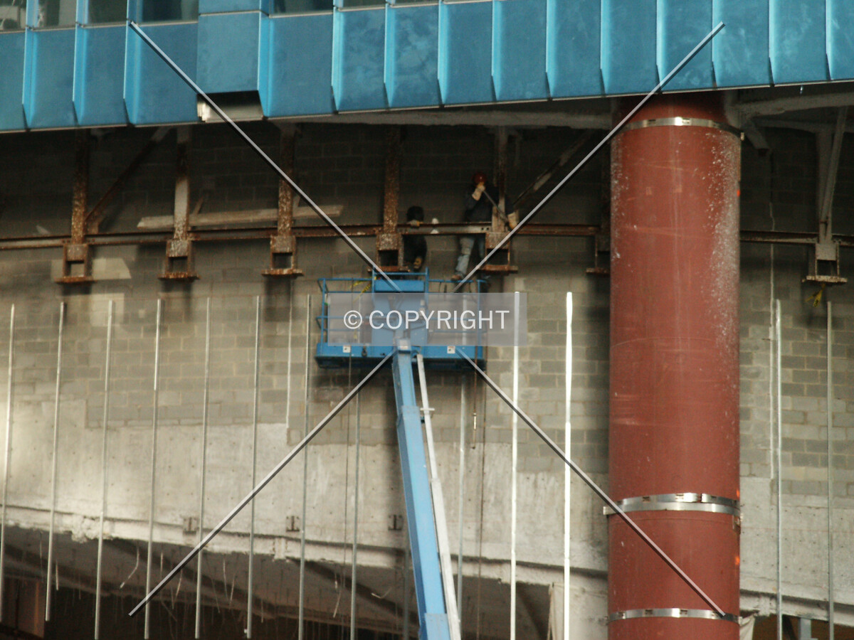 Reaching up to work on the steel