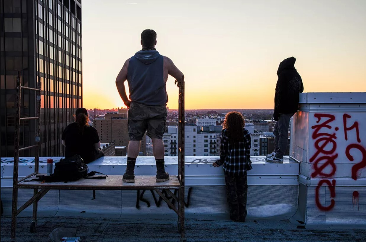 Two urban explorers look out over Downtown St. Louis from the roof