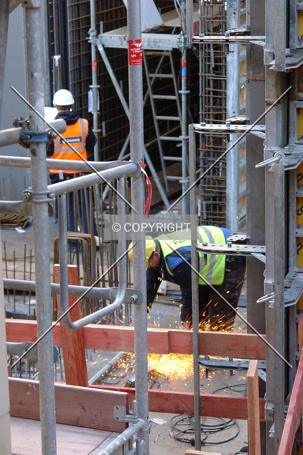 Sparks are created while a construction worker is cutting steel