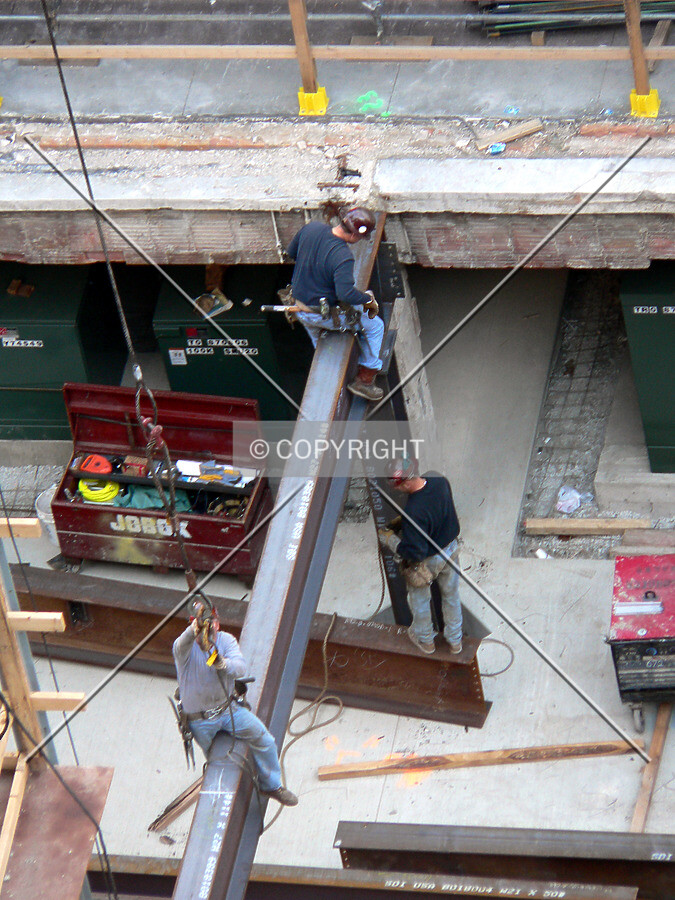 Workers connecting steel beams