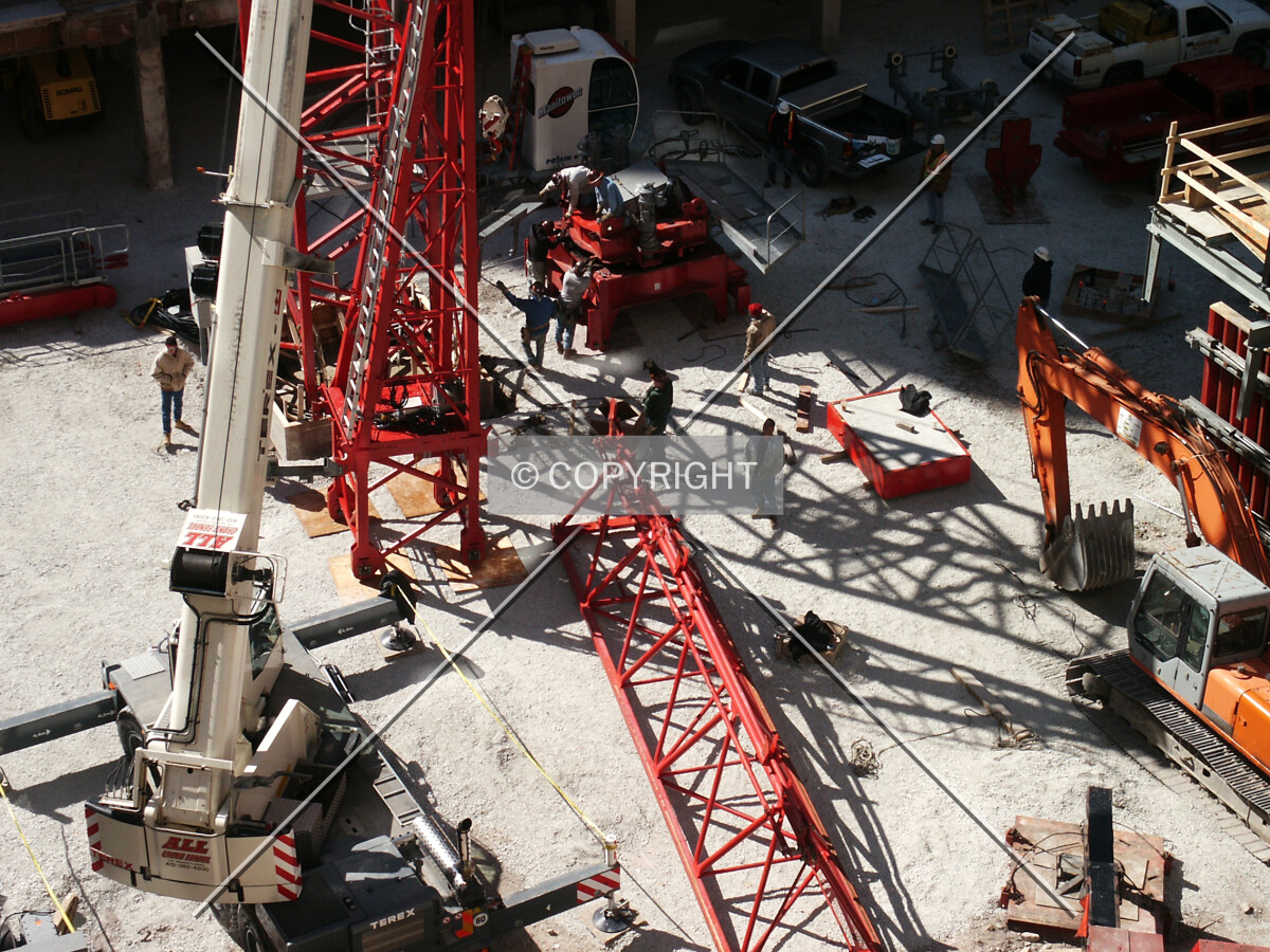 Workers flocking around the tower crane assembly site