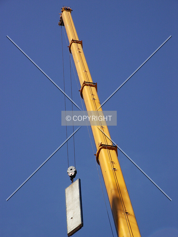 Mobile crane holding a counterweight from the tower crane's boom
