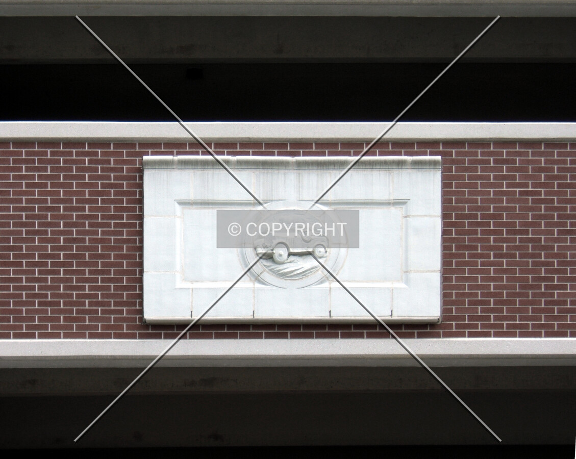 Facade detail showing a medallion from the former garage on this site