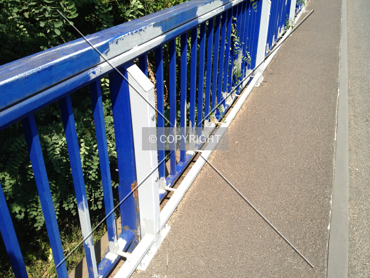 The blue railing of the bridge has been extended with additional steel beams in order to secure the railing