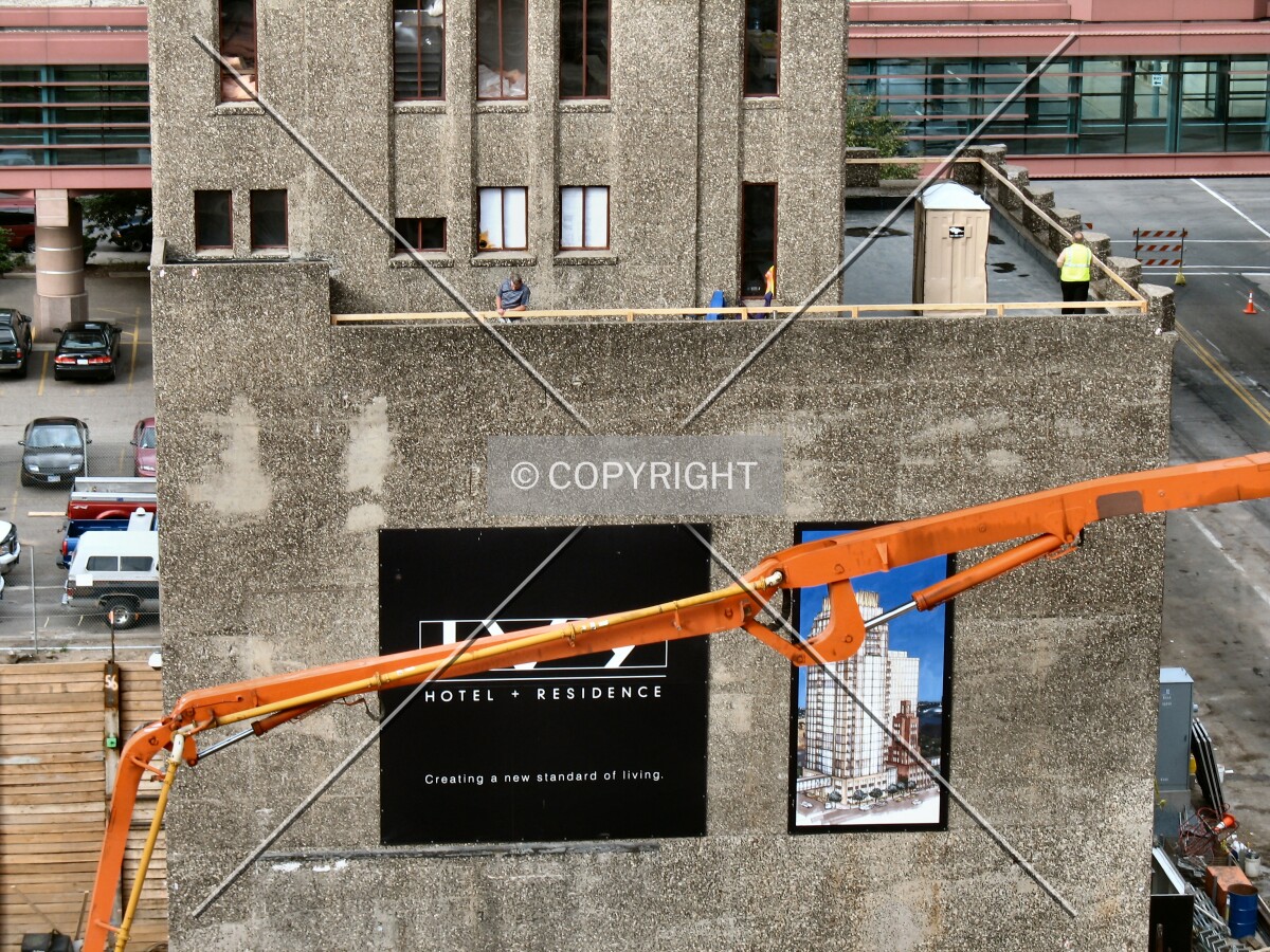 The south concrete pumper in front of the existing Ivy Tower with a rendering of the new structure