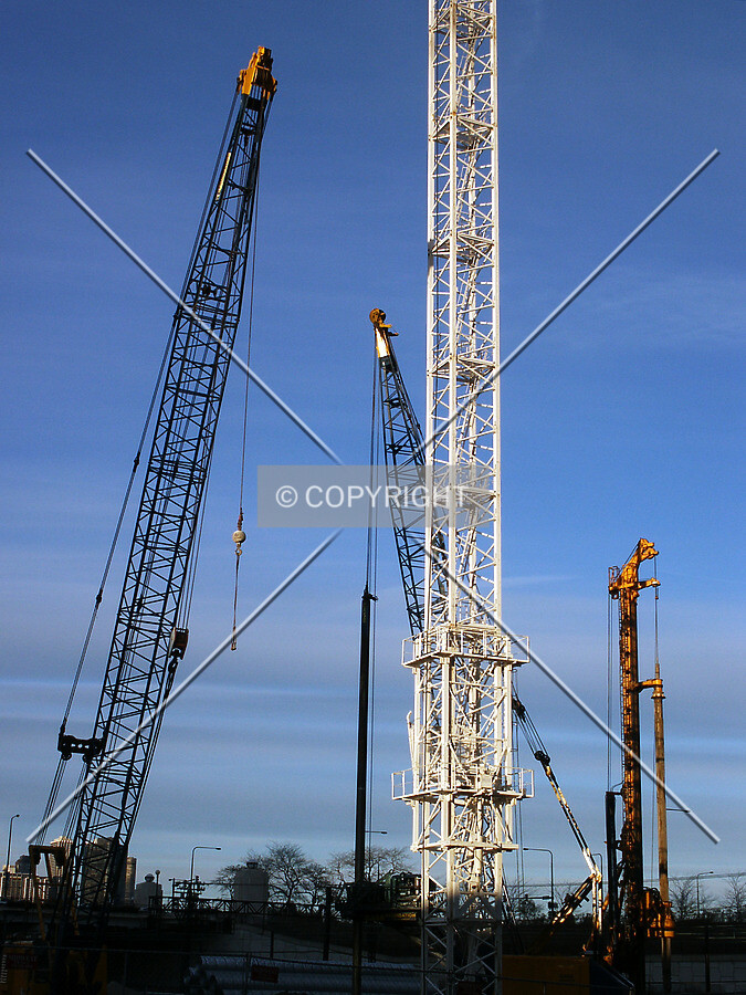 Tower crane stem surrounded by foundation cranes