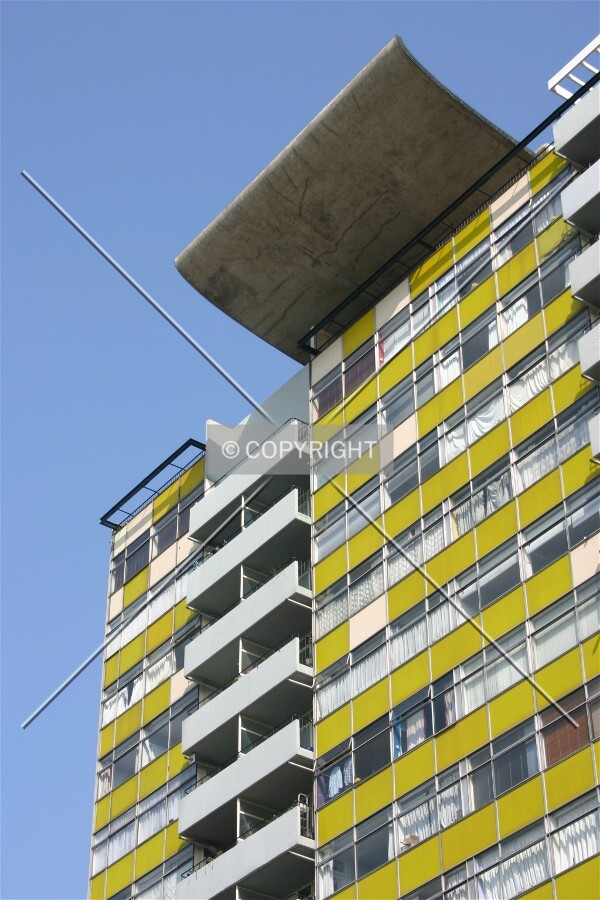 View of the opaque yellow glass façade and distinctive roof canopy