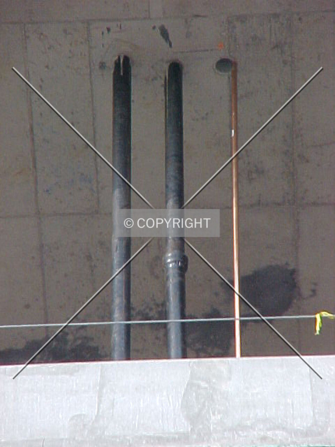 Copper piping and vent stacks rising through the floors