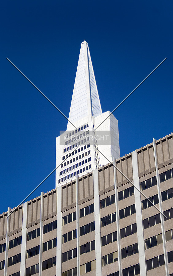 Top floors and spire peering above a neighboring building, from the southwest