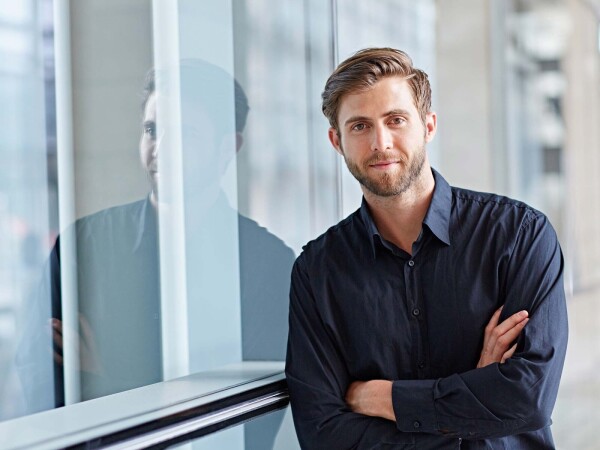 Business professional standing by an office window