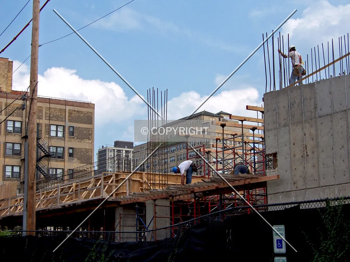 Workers laying temporary decking for the second floor slab