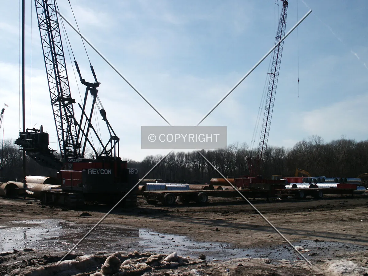 Foundation cranes seen through the north fence
