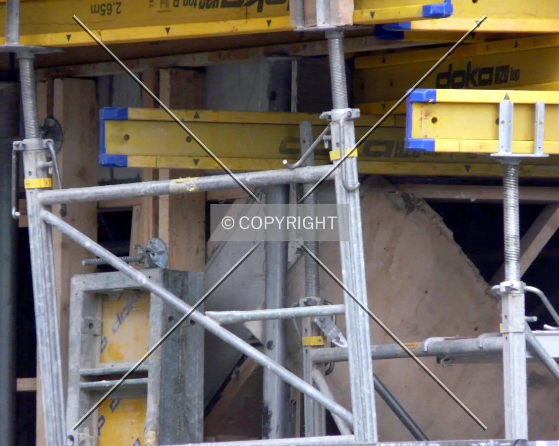 One of the tilted walls of the base, partially hidden by scaffolding