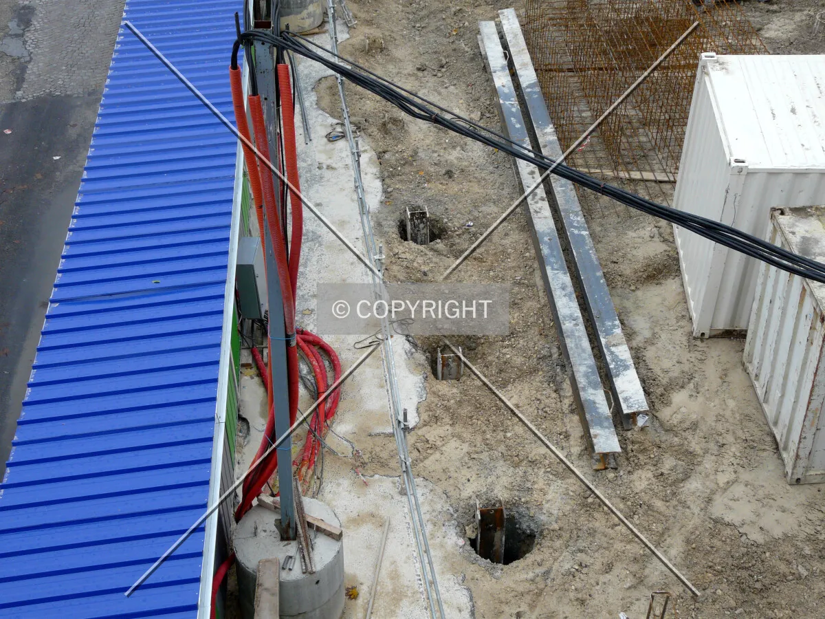 Looking down at piles in the ground along Rue du Chevaleret