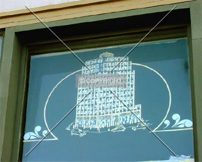 The building rendered on a window of its ground floor shop
