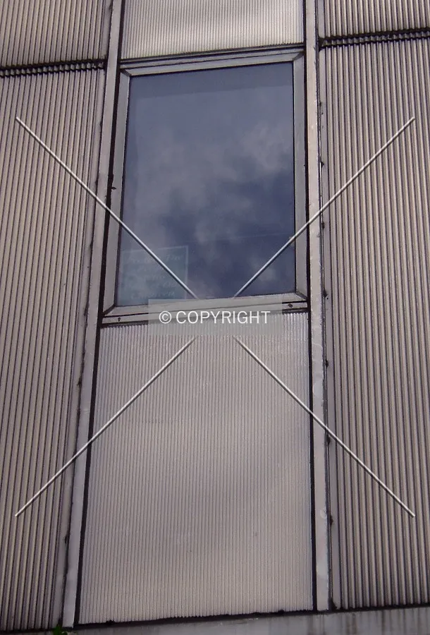 Detail of the facade material and a third floor window