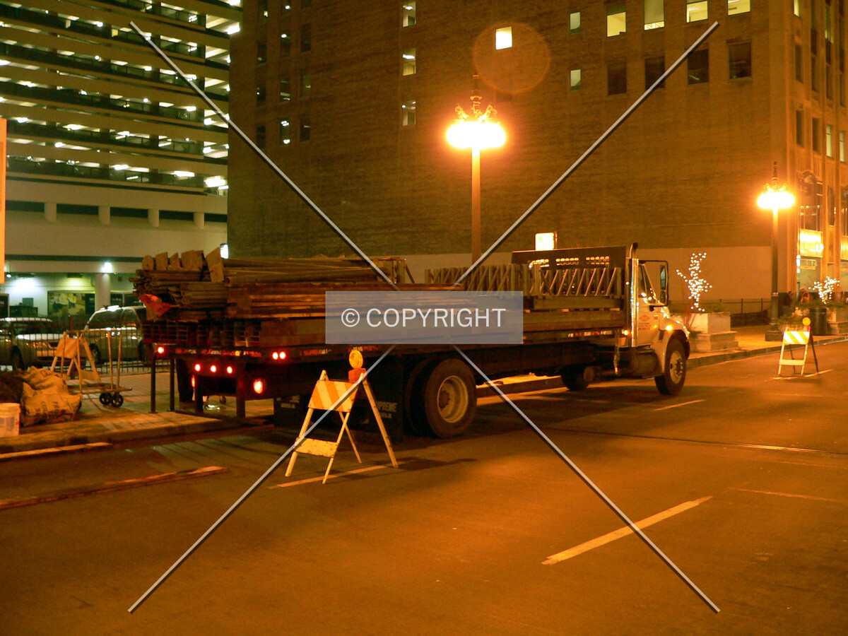 A truck carrying scaffolding that will be erected over the sidewalk