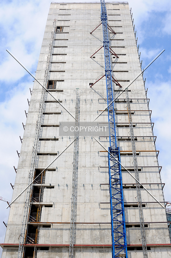 Looking up concrete wall with construction crane