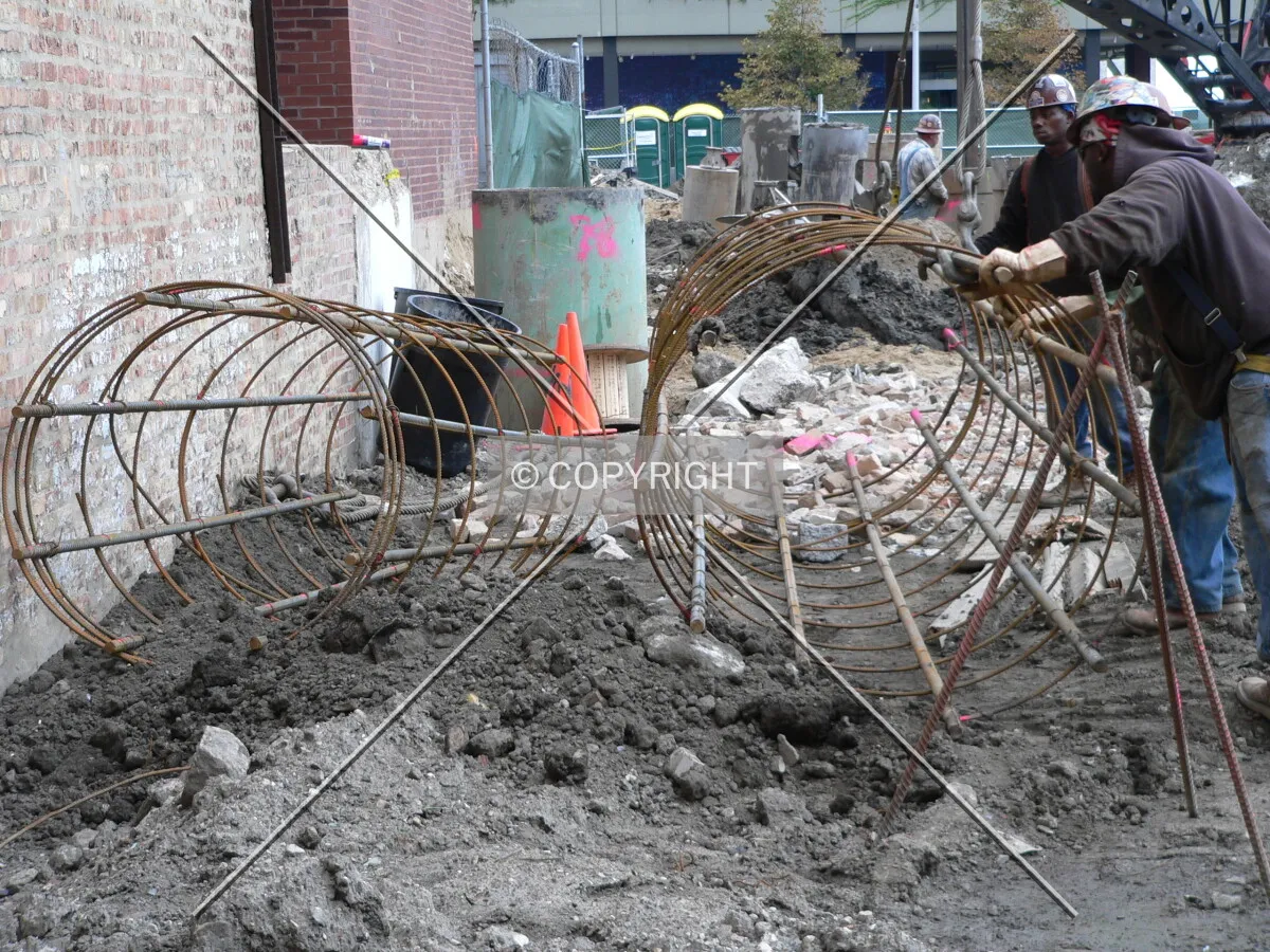 Workers building steel rebar cages for caisson construction