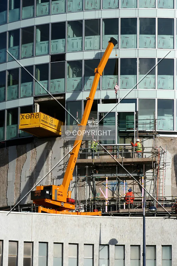 A crane raises a facade panel
