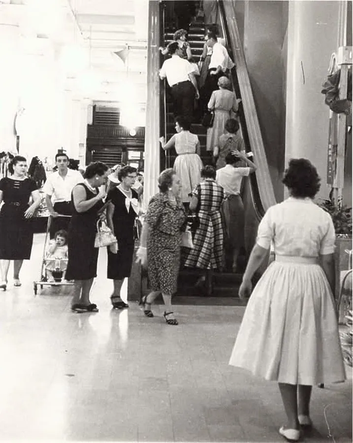 Shoppers boarding an escalator; July 25, 1959