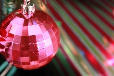 A Christmas ornament dangling above a present