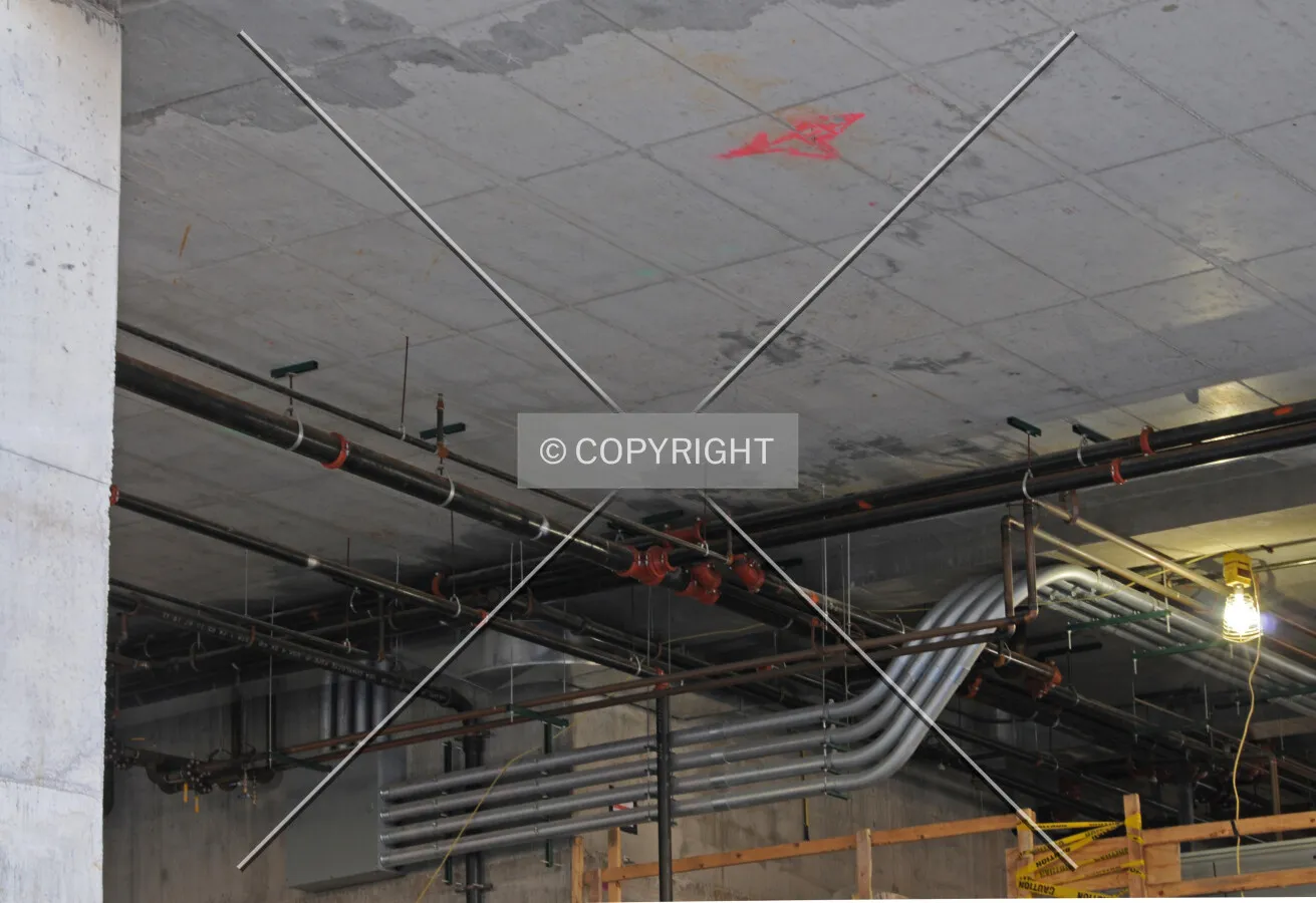 Pluming and electrical conduit attached to the walls and ceiling of the future lobby