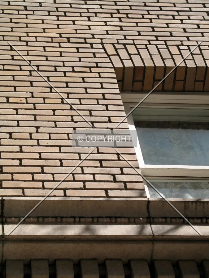 Thick, multi-layered brick facade and recessed windows