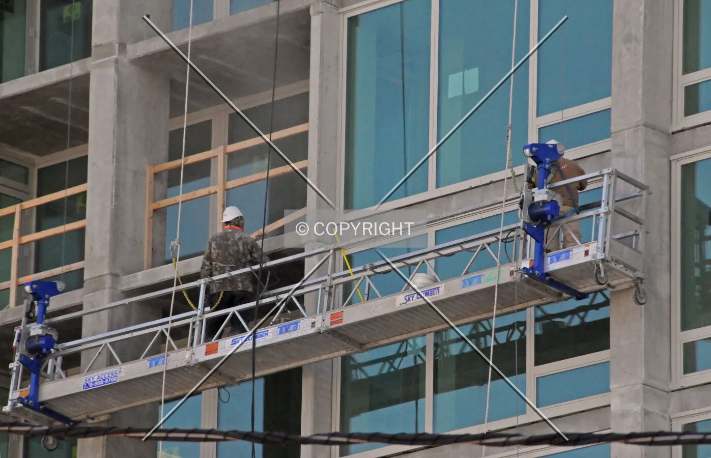 Workers smoothing out rough spots in the concrete facade