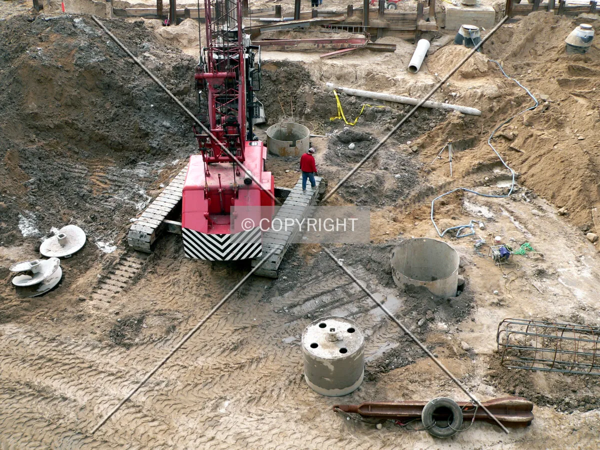 View into the construction site with several drilled caissons visible