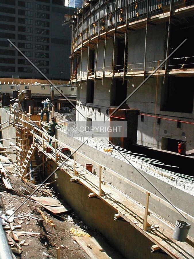 Workers erecting a foundation wall along Monroe Street