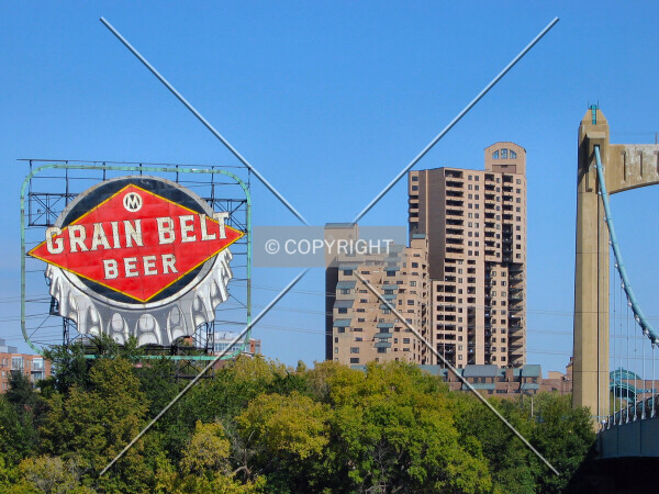 View to the northeast from across the Mississippi River, framed by the Grain Belt Sign and the Hennepin Avenue Bridge