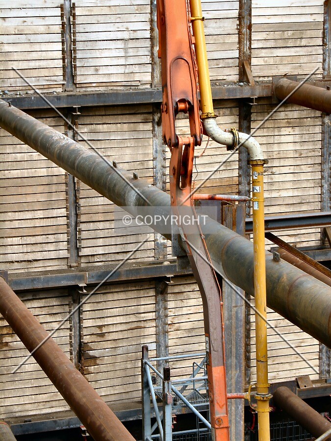 One of the concrete pumpers descends into the deep pit