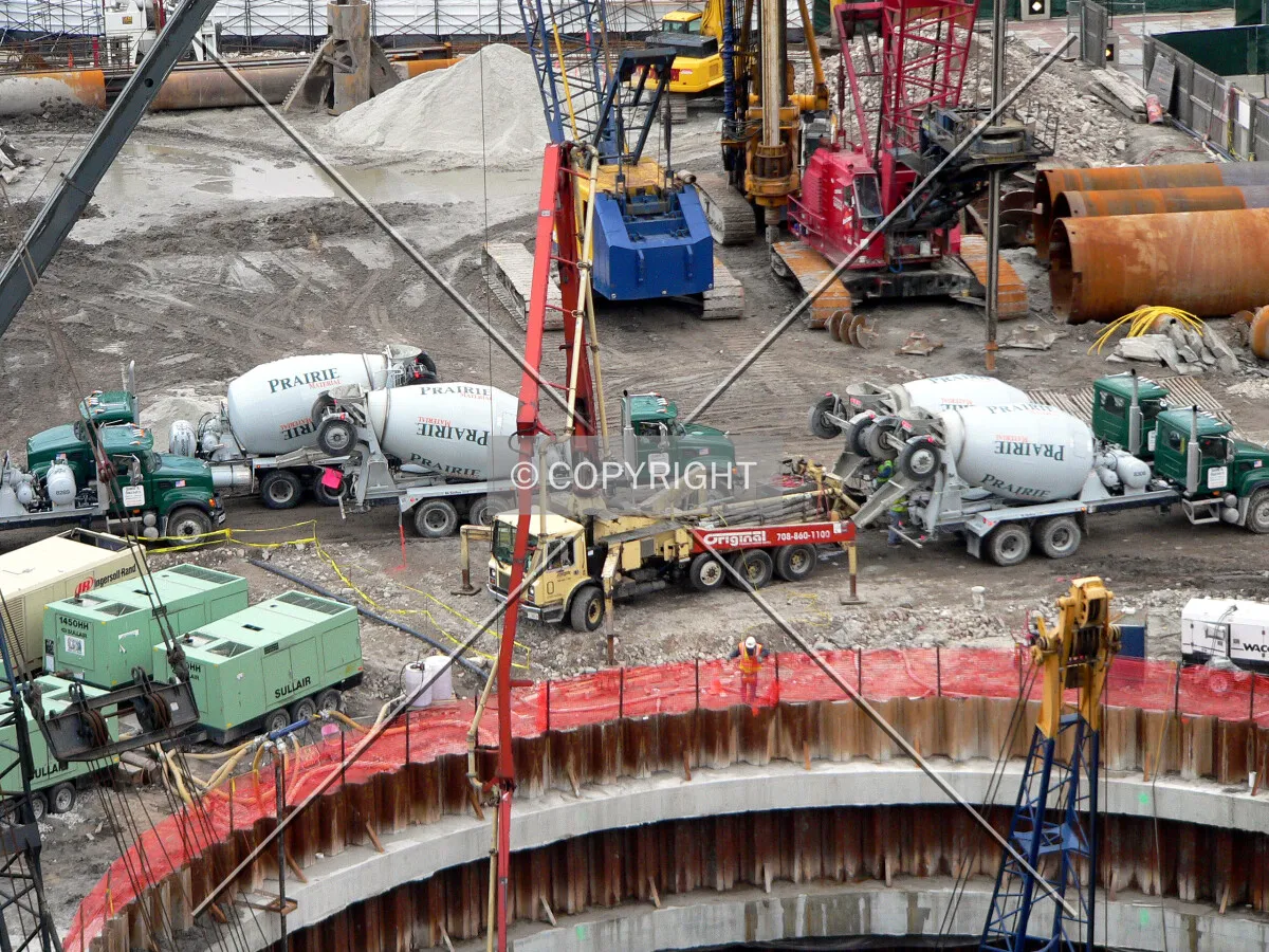Concrete trucks lined up to pump concrete into a caisson hole