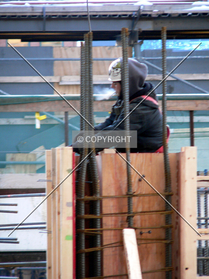 Worker standing in the formwork of a future column