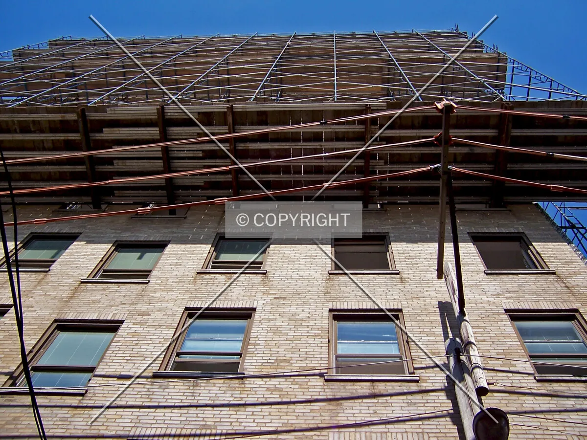 Look up the south facade from the alley. The south end of the mid-rise tower has been shrouded in scaffolding for demolition