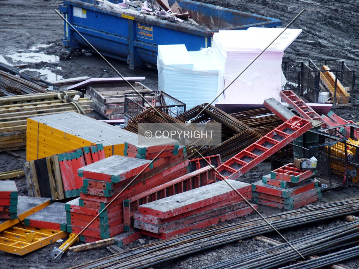 Rebar, formwork, stacks of styrofoam, and a dumpster