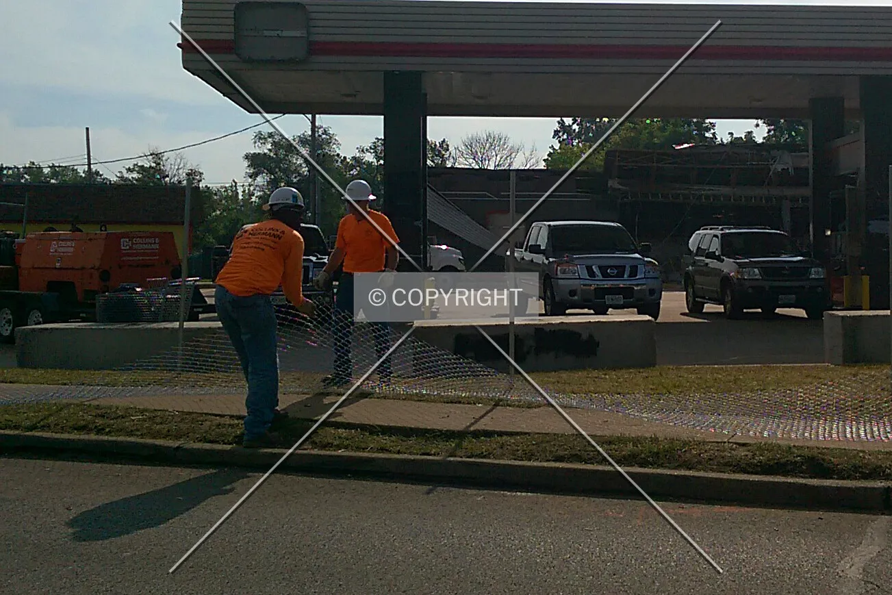 Workers fencing off the property after being looted and set on fire; August 19, 2014