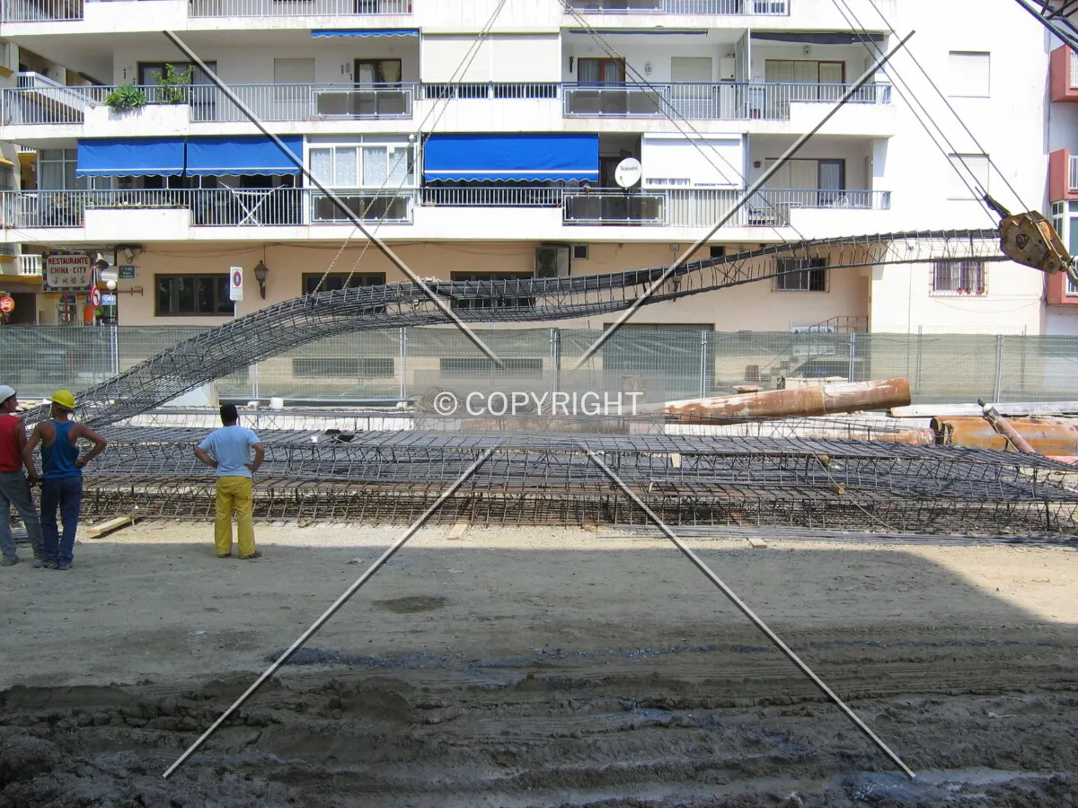 Crane raising steel bars for concrete wall
