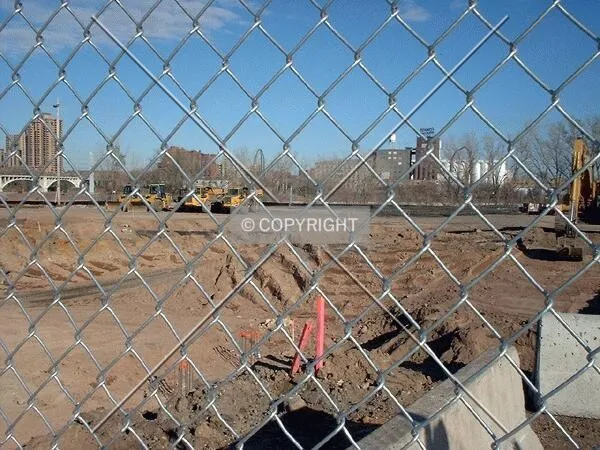 View to the northwest across the construction site, through chainlink fencing