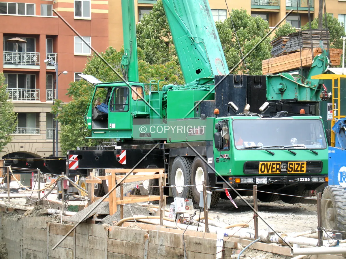 Temporary, mobile crane helping hoist the new tower crane sections into position for assembly