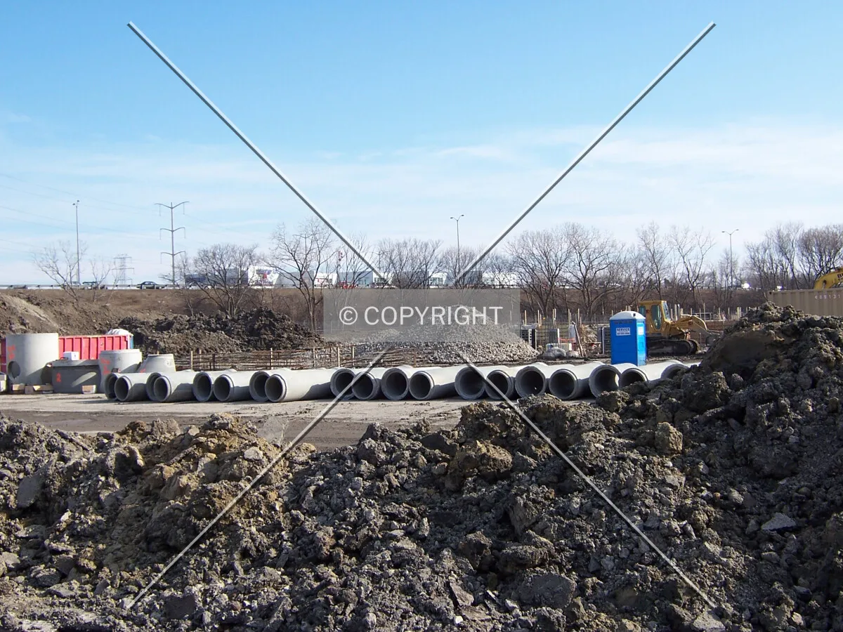 Looking southeast into the site. Concrete sewer pipes and caisson rebar cages are lined up in the background