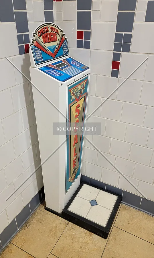 A scale just inside the men's restroom in the food court; November 2, 2023