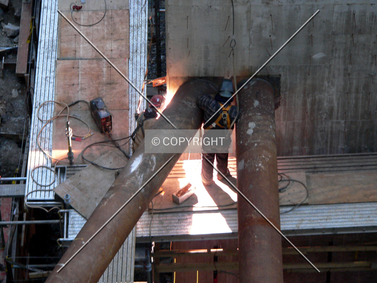 Welders connecting raker beams to the core