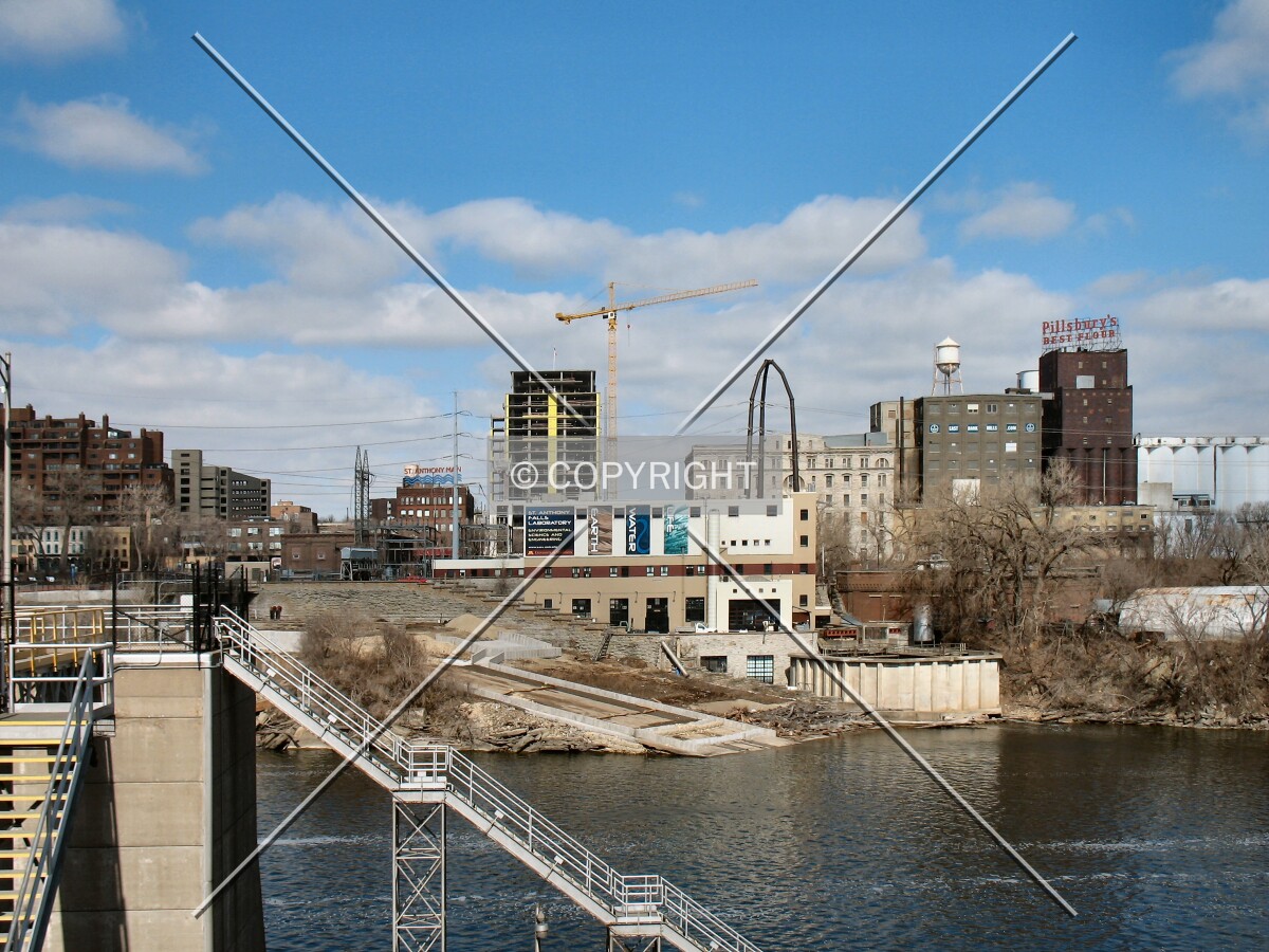 Distant view to the north from the Stone Arch Bridge, past the Upper St. Anthony Lock on the Mississippi River, with the Pillsbury A Mill