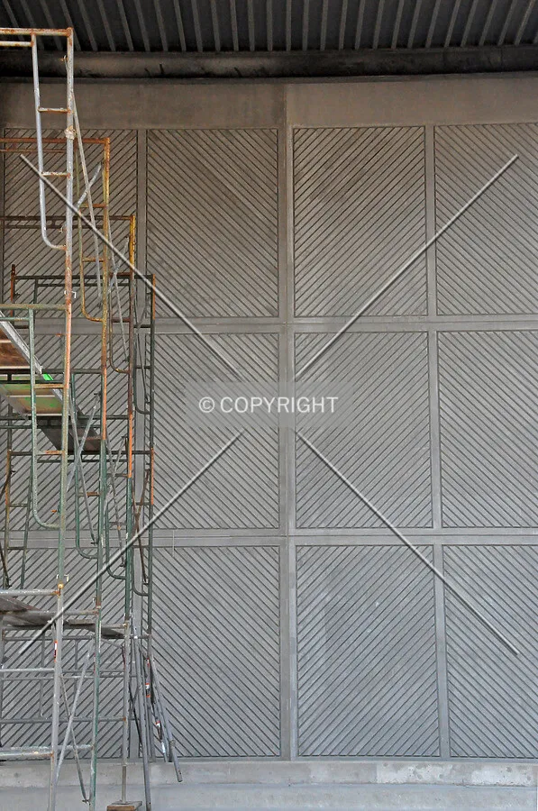 Textured precast concrete panels beside the driveway