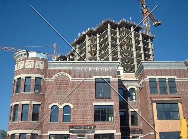 Tower rising above townhomes, from Portland Avenue